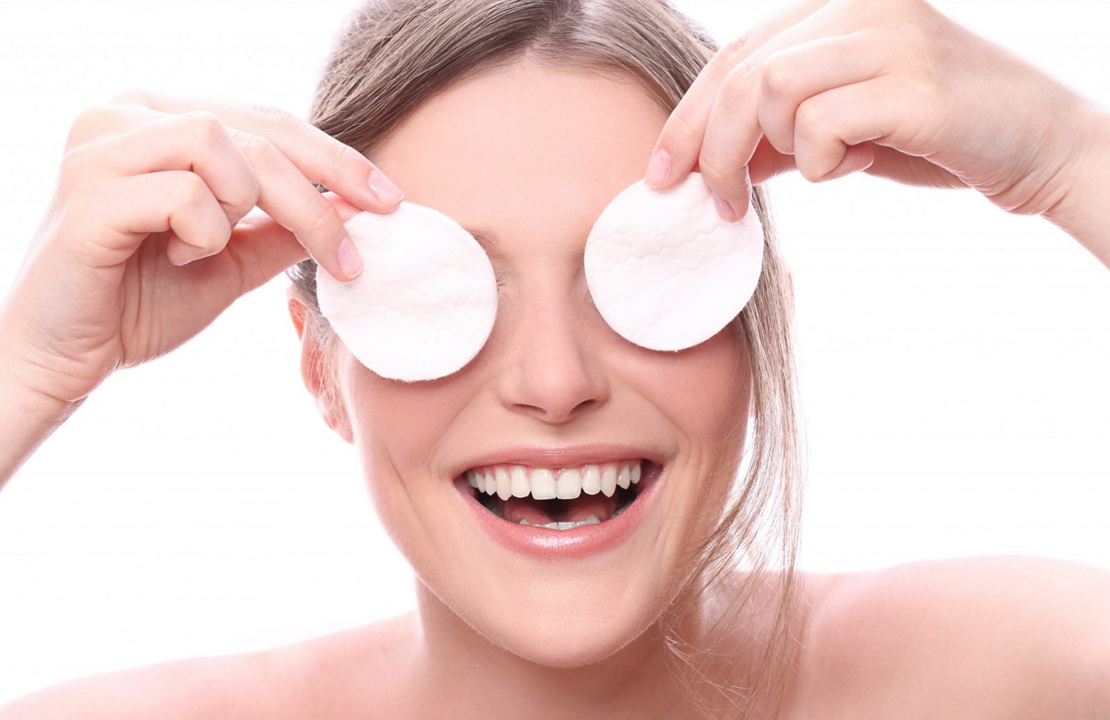 jovem sorri com algodões nos olhos após peeling
