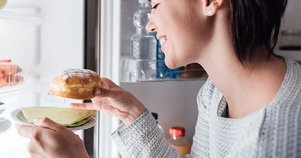 mulher com sugar craving retira bolo do frigorífico